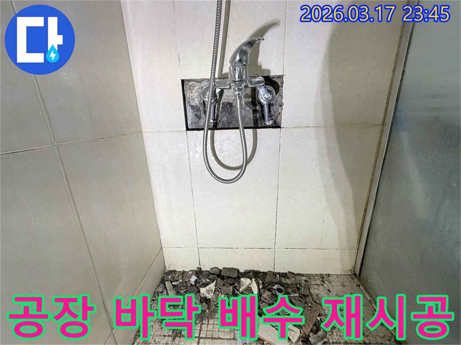 병점 화성 공장 화장실에서-바닥 배수 불량 배관 점검 및 재시공을 위해-샤워 수전이 제거되고-바닥 타일이 파손된 채로-공사가 진행 중인 모습입니다.