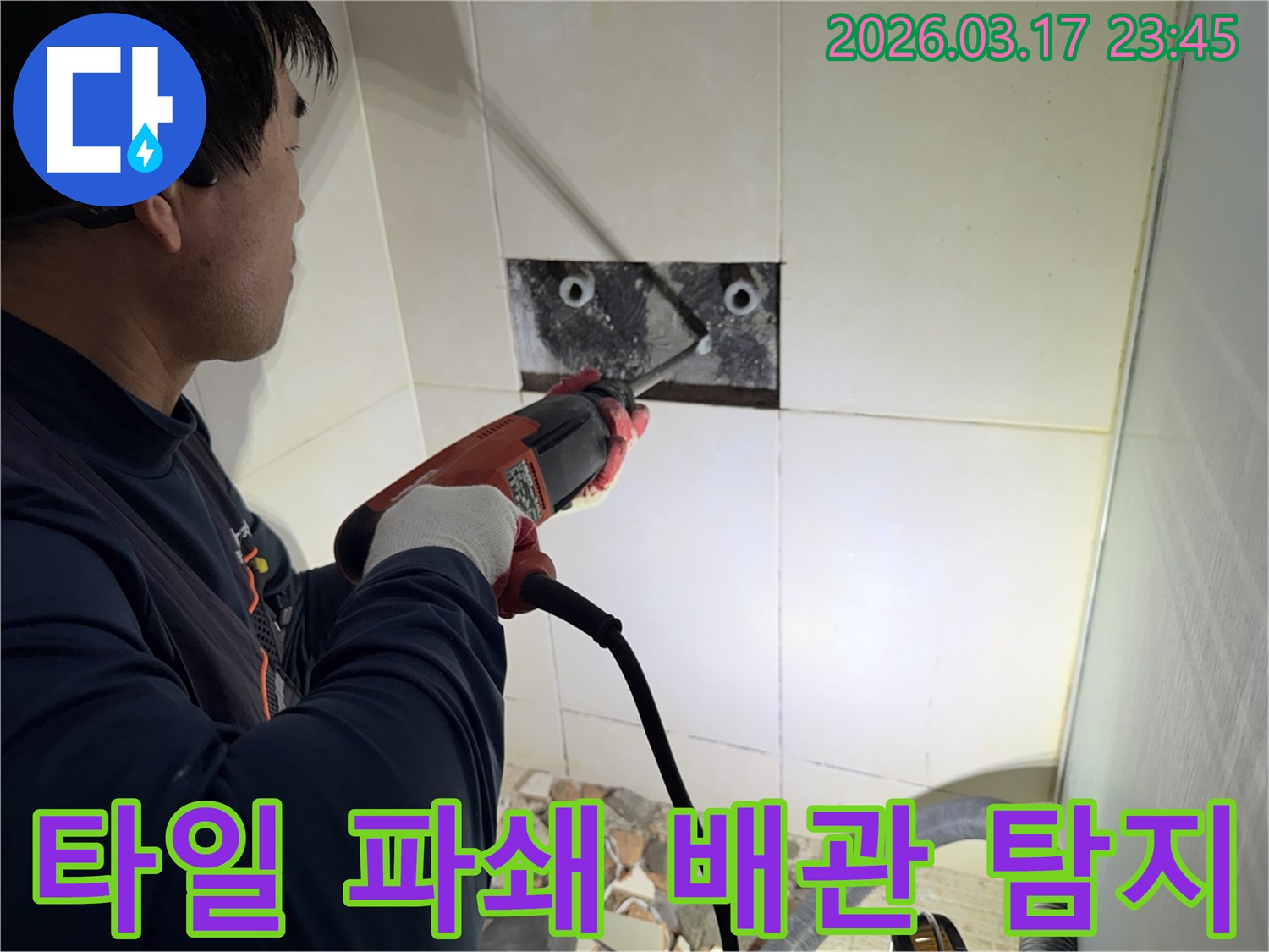 숙련된 기술자가 빌라 누수 지점을 찾아내기 위해-벽면 타일을 깨고 내부 배관을 드러내어-정밀 탐지하는 작업을 진행하고 있습니다.