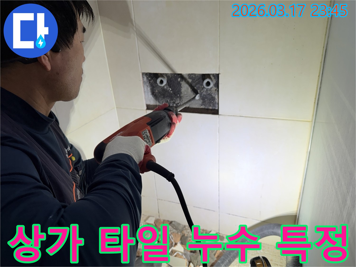 숙련된 기술자가 상가 누수 지점을 찾아내기 위해-벽면 타일을 깨고 내부 배관의 누수 지점을 특정하는 작업을 진행하고 있습니다.