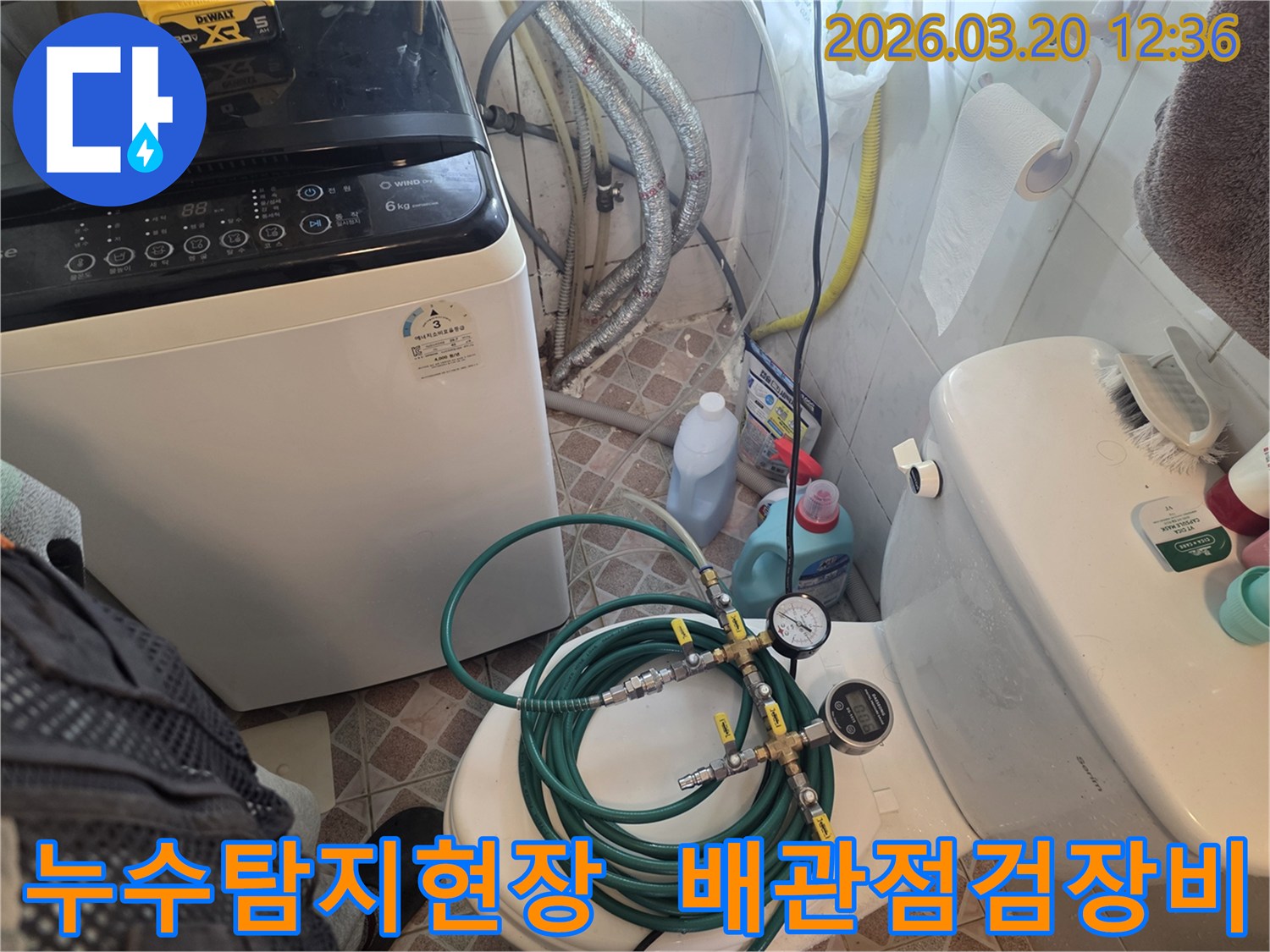 누수 엔지니어가 화장실에서 세탁기 옆 배관과 변기 주변을-정밀 누수 탐지 장비로 검사하며-누수 원인을 파악하고 있습니다
