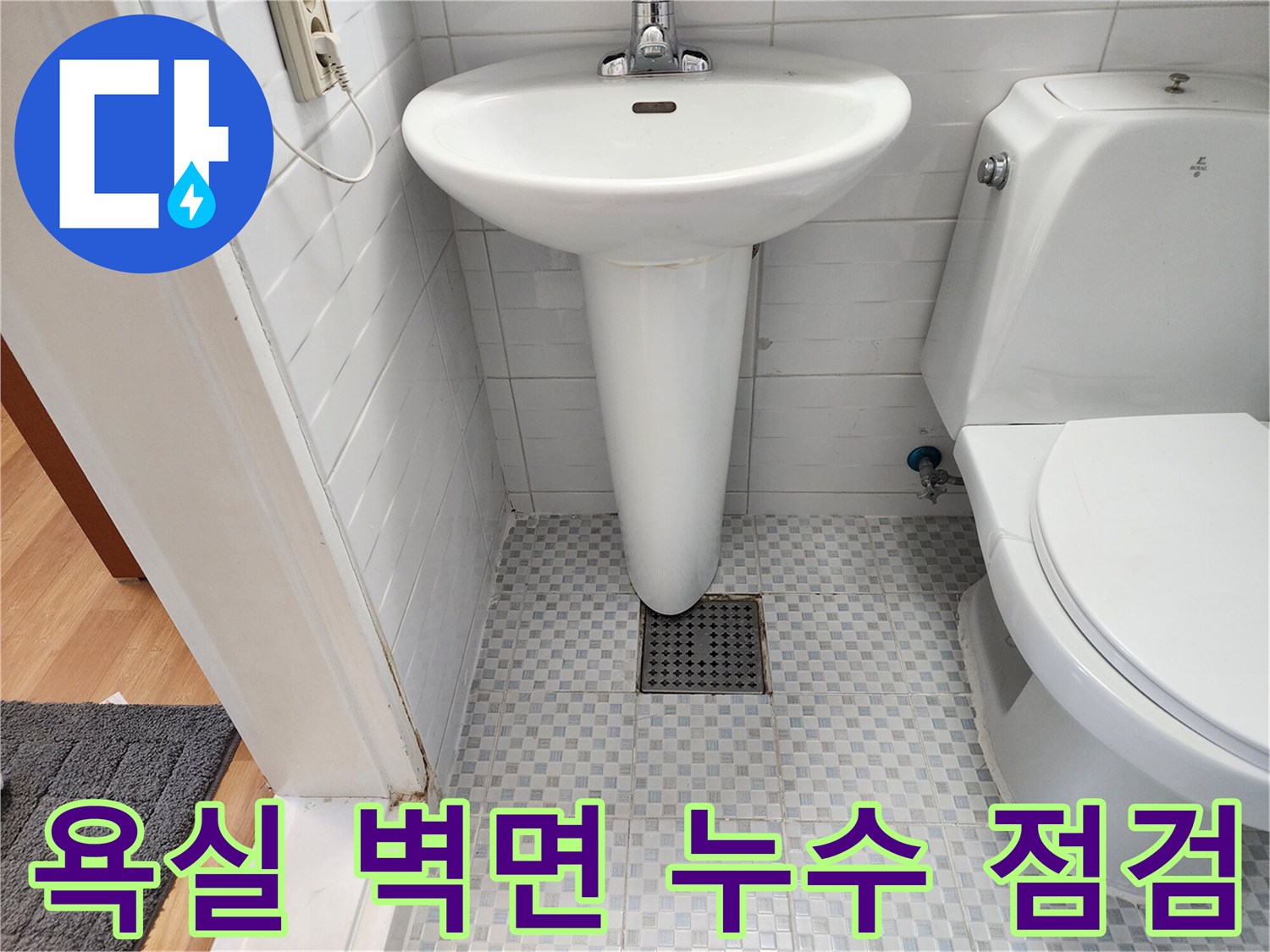 변기 옆 타일 벽면에 위치한 배수구와 배관 부위