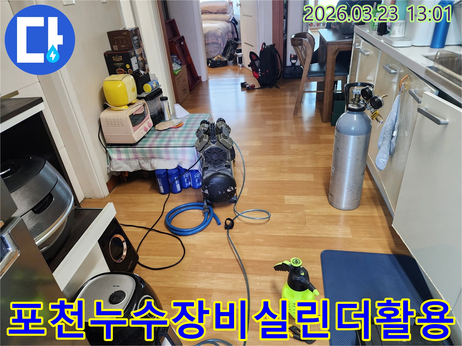실내에서 누수 탐지를 위해-가스 실린더와 압력 테스트 장비를 연결하고-작업을 준비하는 엔지니어의 모습