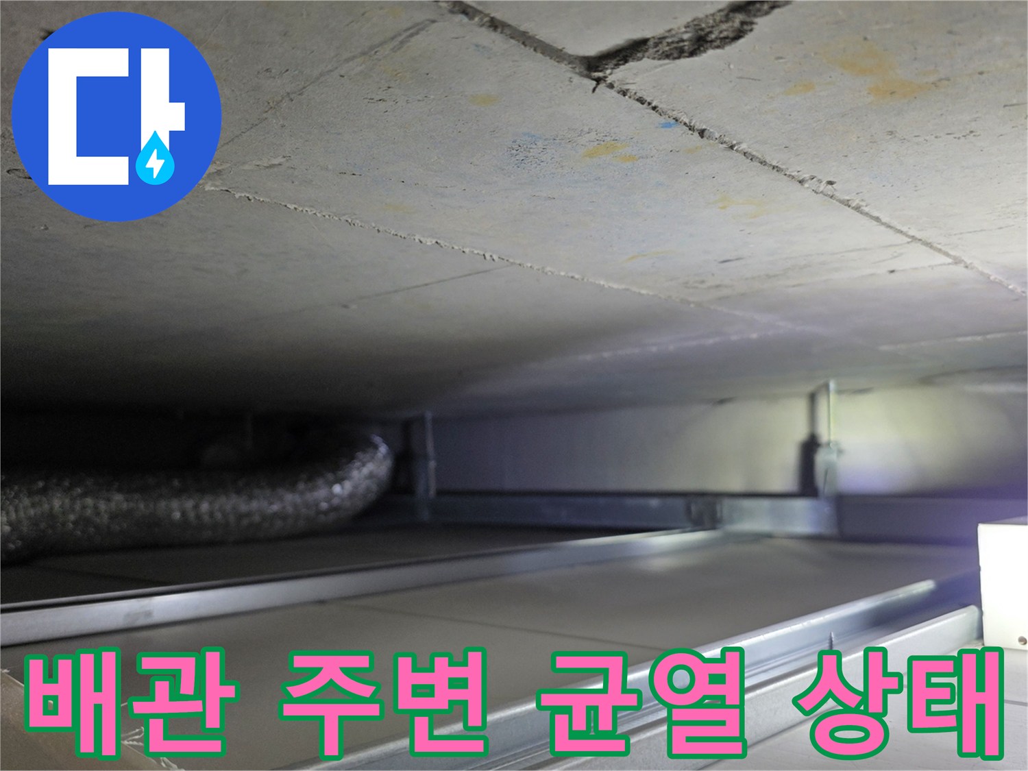 천장 콘크리트 균열과 은색 자재 배관의 모습