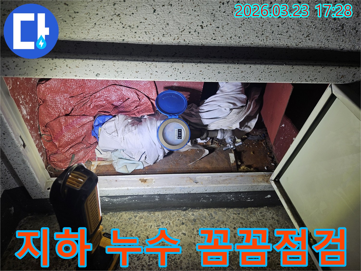 수도 계량기 덮개를 열고 내부 상태를 점검하며 누수 지점을 파악하는 작업