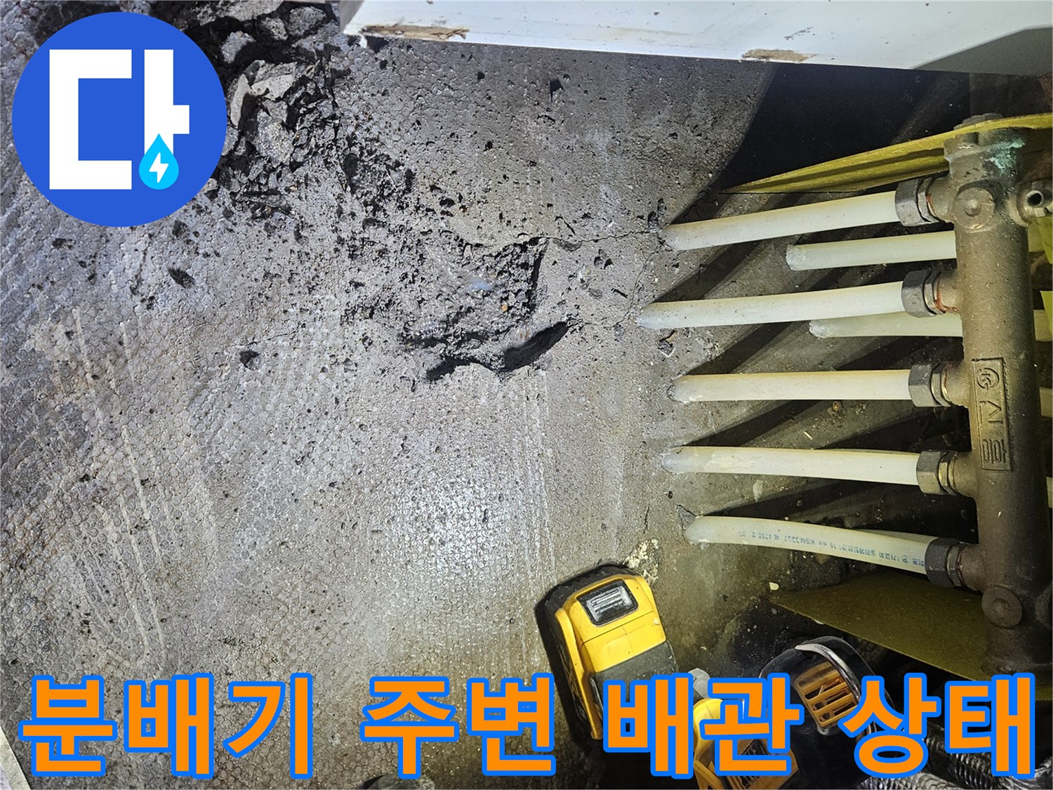 싱크대 아래 젖은 바닥과 분배기 연결부 근처 모습
