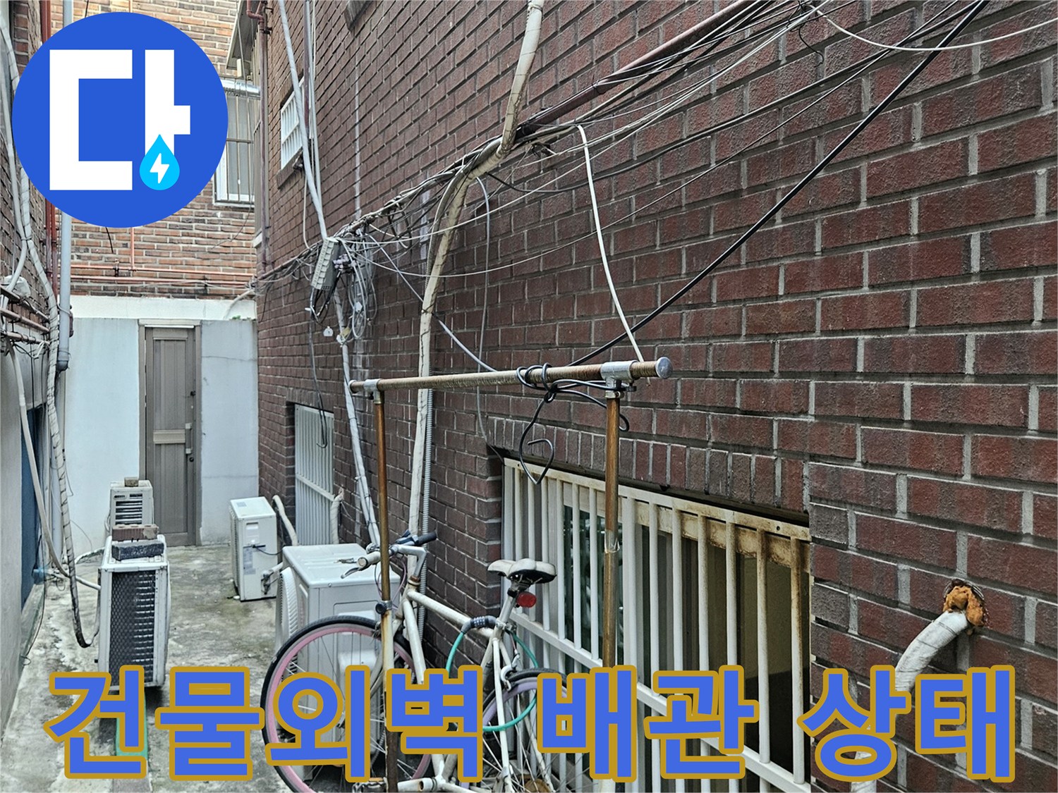 중랑구 건물 외벽의 붉은색 타일과 복잡하게 얽힌 외부 배관 모습