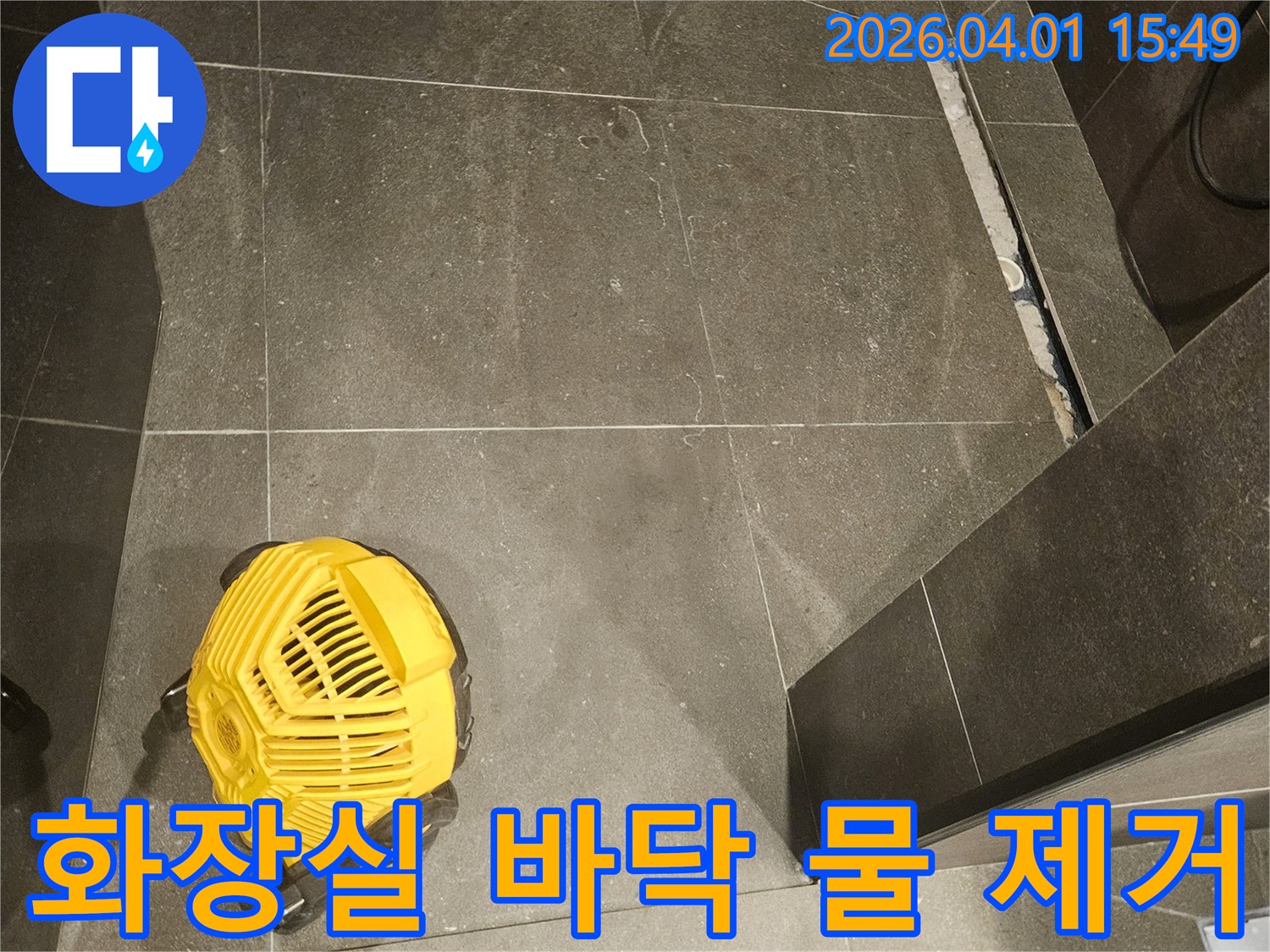 화장실-누수-현장에서-바닥의-물을-효과적으로-제거하는-전문-습식-청소기-사용-모습