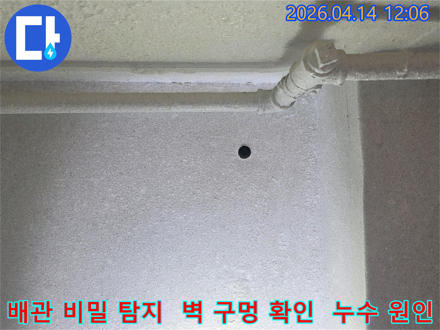 갈현동 현대아파트에서-누수의 비밀을 풀기 위해-벽에 뚫은 작은 구멍과-주변 배관을 보여줍니다