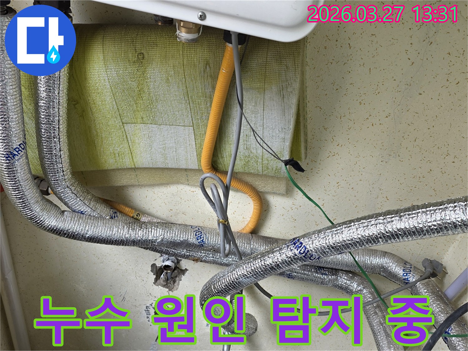 벽면에-설치된-보일러-아래쪽의-다양한-배관과-전선이-연결된-모습을-보여주며-누수-원인-탐지-전-현장-상황을-기록합니다.