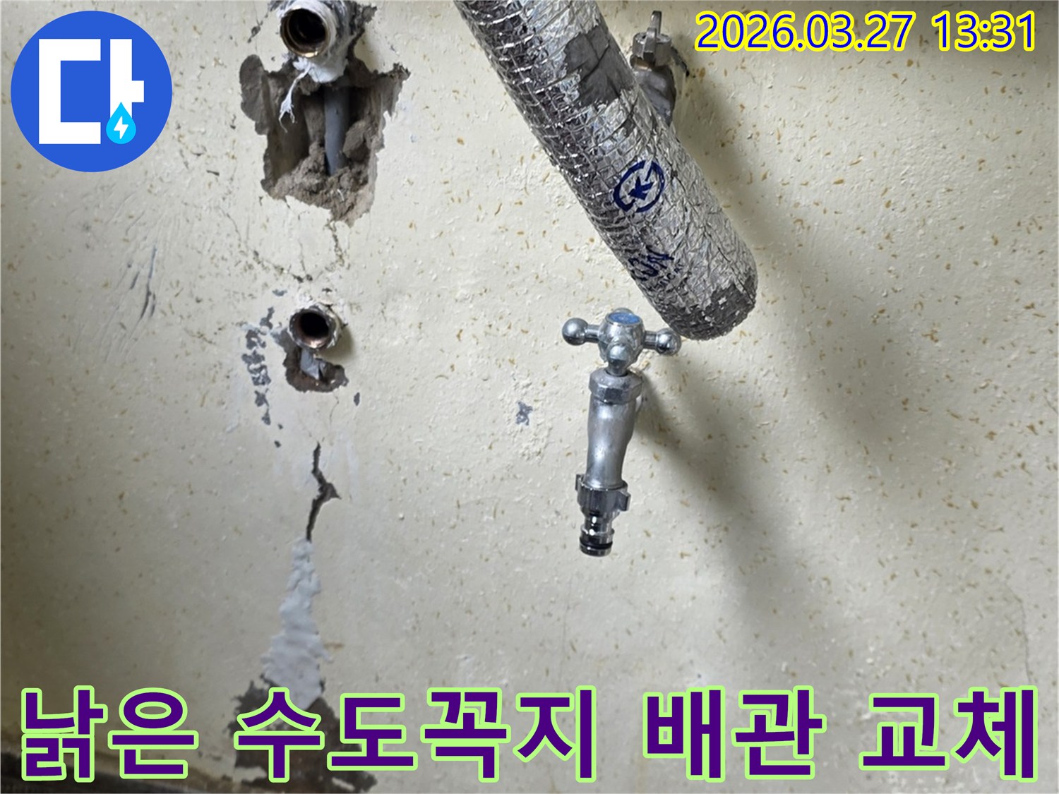 이 사진은 오래된 수도꼭지와-벽면이 개방된-배관 연결부를 보여주며-누수 수리 전의 현장 모습입니다.