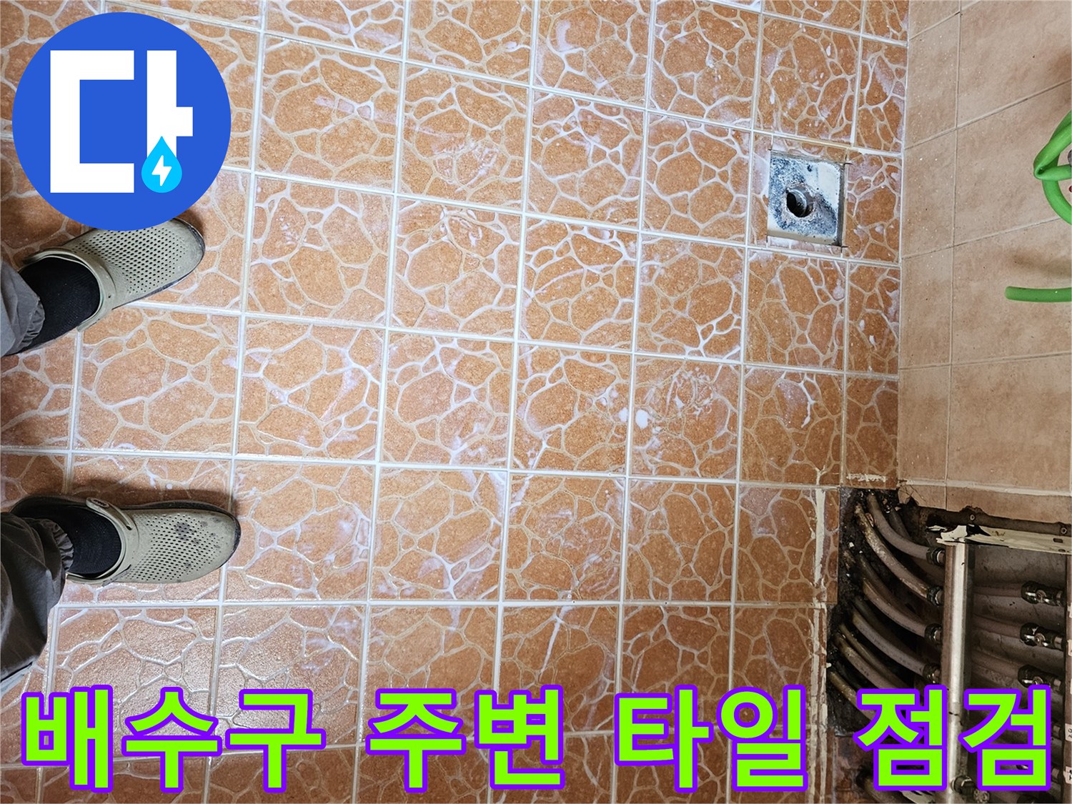 갈색 패턴 타일과 금속 재질의 배수구 덮개 사진