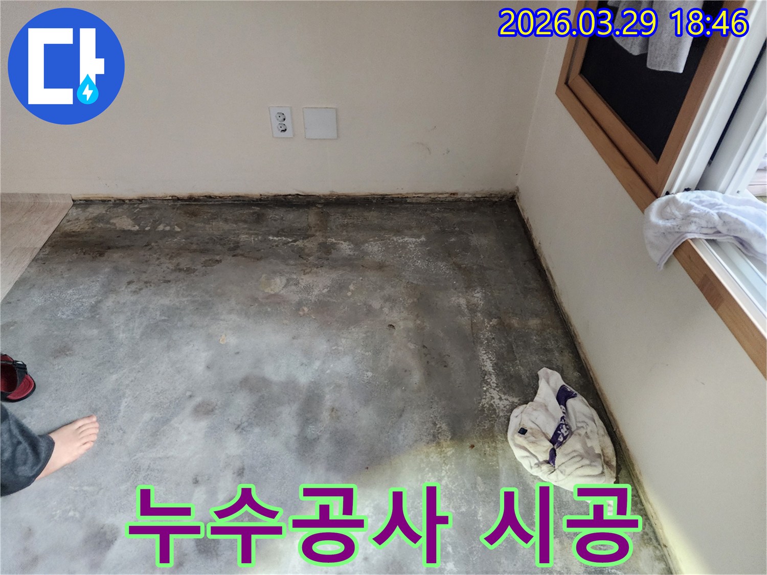 이 이미지는-남양주 오남읍의 한 건물에서-바닥과 벽면 경계에-습기와 곰팡이가 발생한-누수 현장을-보여주며-누수 공사의 필요성을-강조합니다