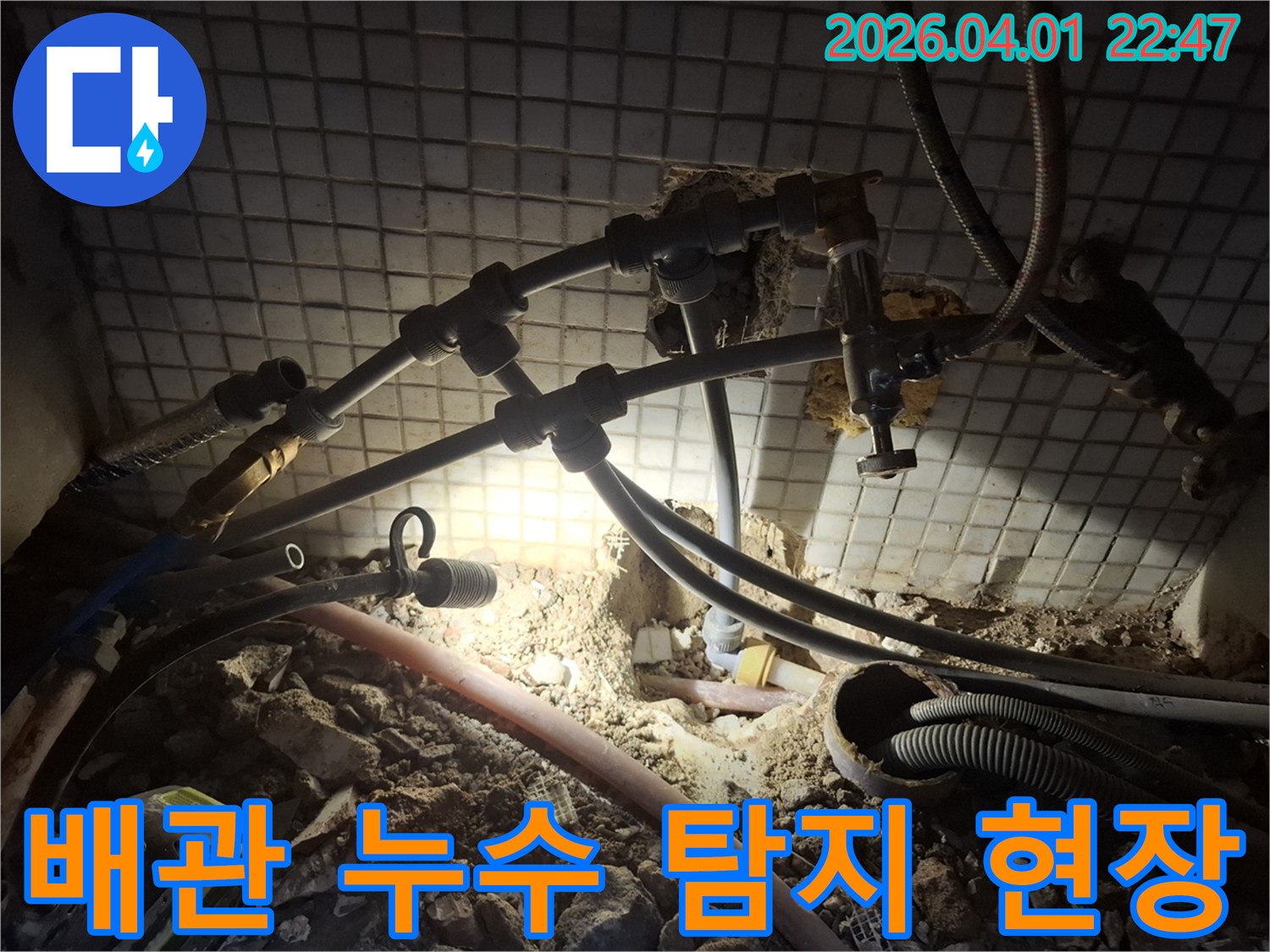 어두운 공간에서-누수 지점을 찾기 위해-배관 주변을 탐색하는 모습