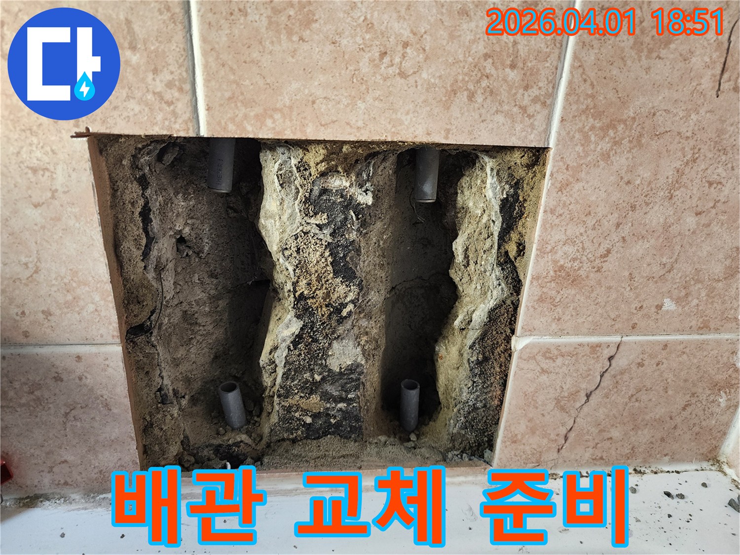 욕실 타일 벽면을 파쇄하여-누수 지점의 배관을 노출시키고-교체를 준비하는 공사 모습