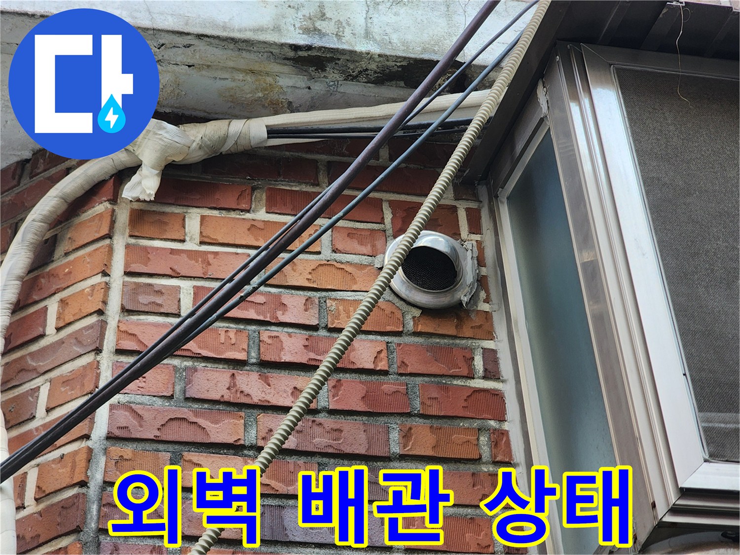 붉은 벽돌 외벽에 설치된 배관과 연결 부위 모습