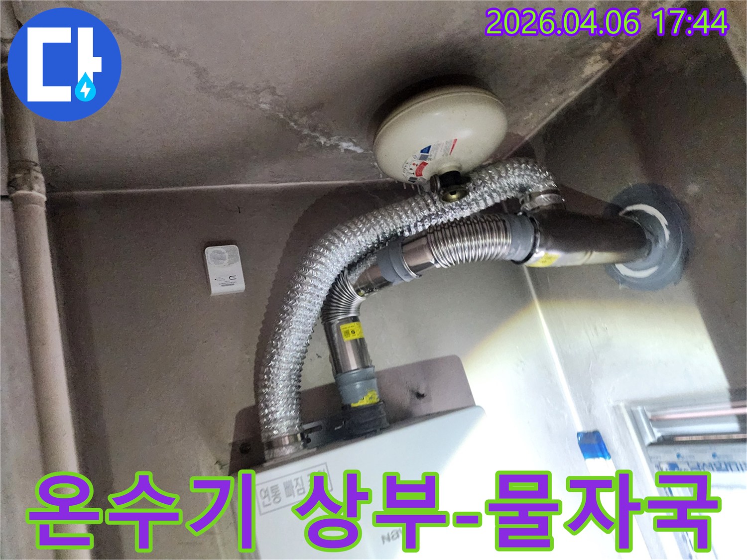 이 이미지는 온수기 상부 천장에 생긴 물자국과-주변 배관의 상태를 상세히 보여주고 있습니다