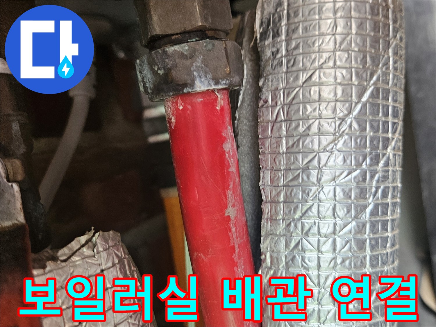 은박 보온재로 감싸진 배관과 붉은색 수도 라인의 결합 부위 상세 촬영