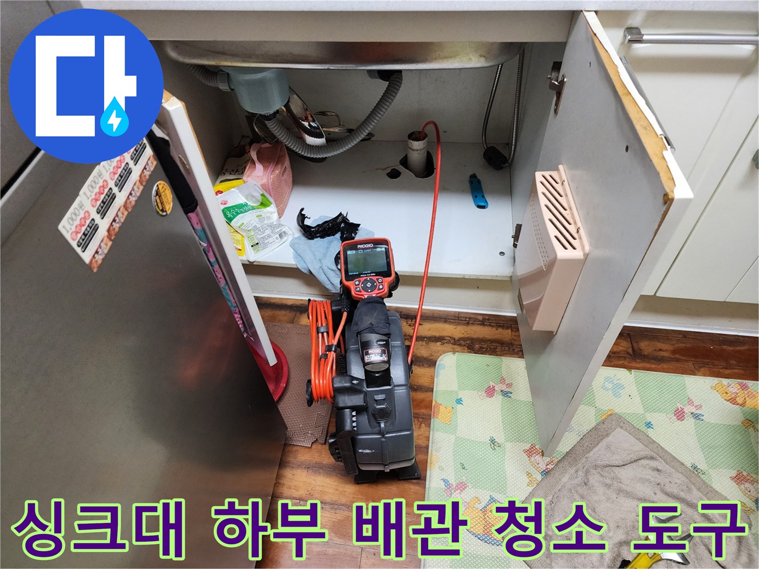 싱크대 아래쪽 배관 점검을 위해 배치된 석션 장비와 호스