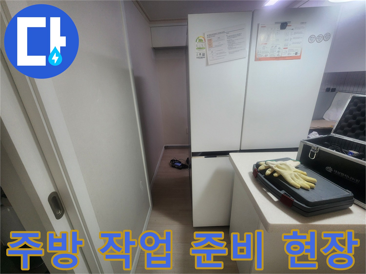 주방 냉장고 옆 - 작업용 장갑과 장비가 놓인 상태