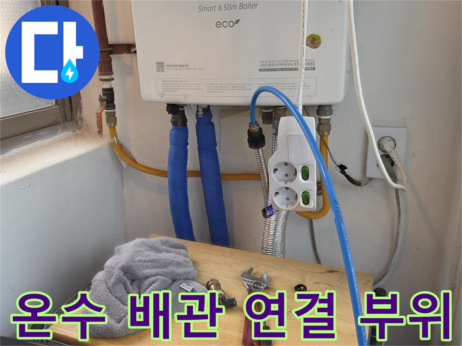 보일러 본체 아래로 뻗어 나온 파란색 급수 호스 모습