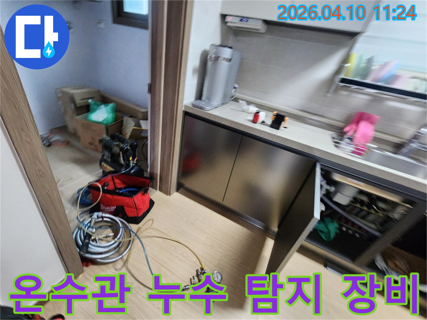 주방-온수관-누수를-탐지하기-위해-장비를-설치하는-모습