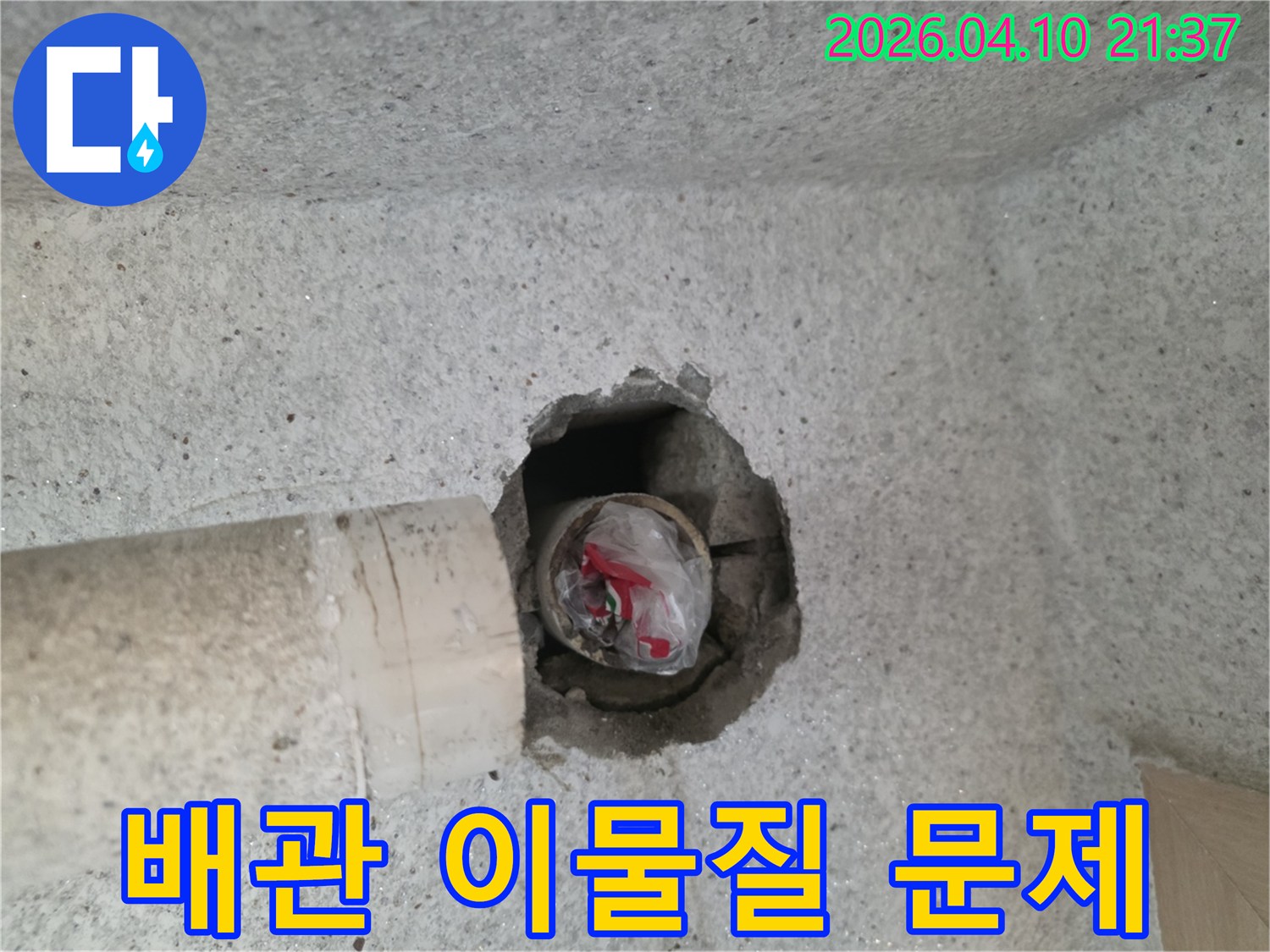 콘크리트 벽면의-배관 구멍에-비닐과-이물질이-채워져 있는-모습을-확대한-사진입니다