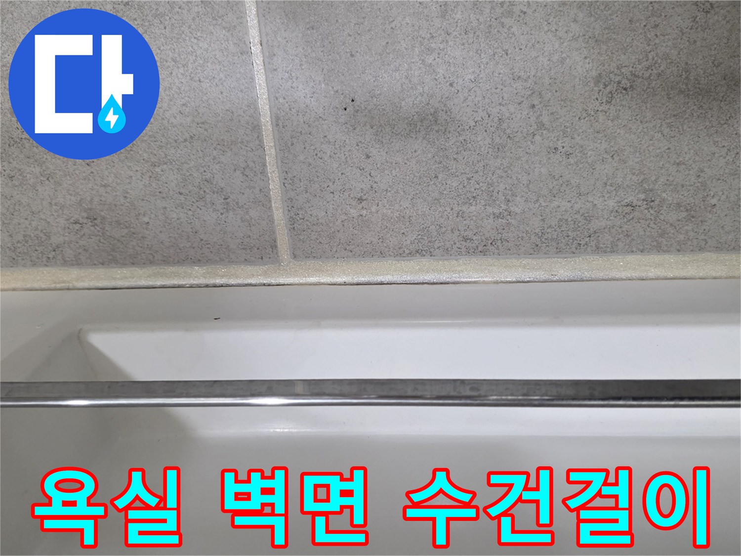 수건걸이가 설치된 화장실 벽면과 바닥 타일 경계