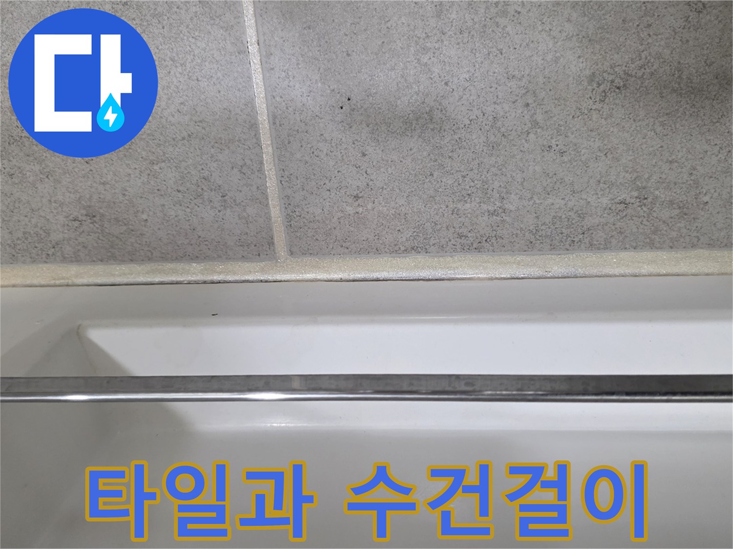 스테인리스 소재의 수건걸이와 회색 타일 바닥