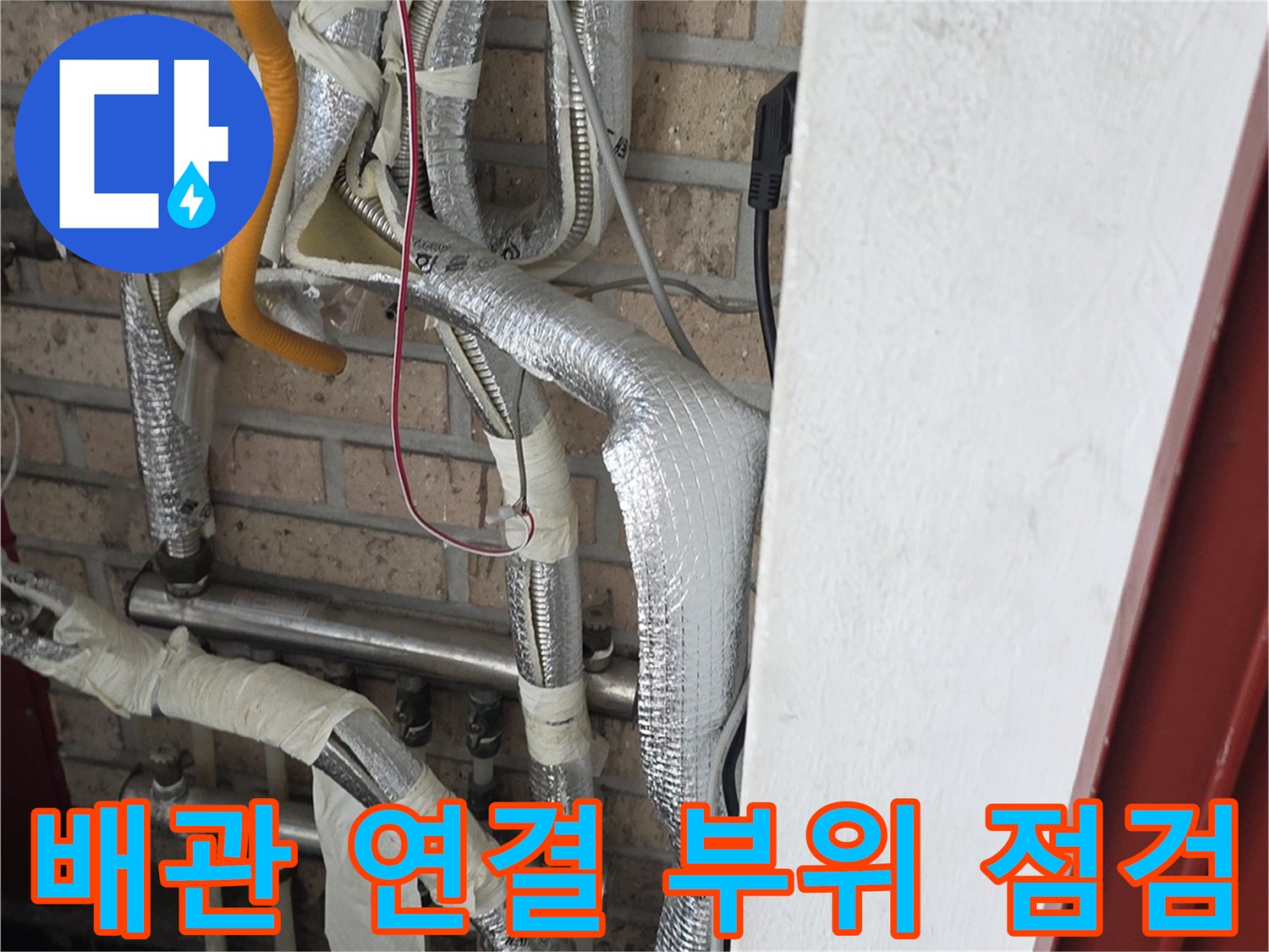 세탁실 내부 배관-은색 보온재와 노란 호스가 연결된 모습