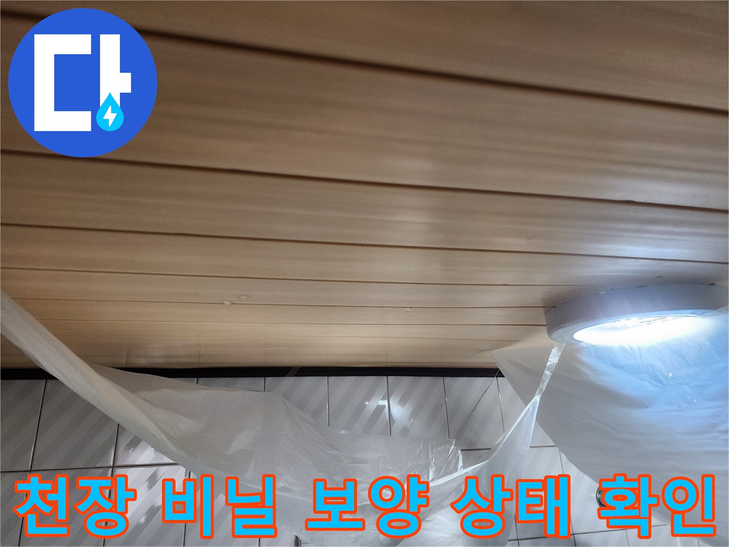 비닐이 씌워진 화장실 천장 마감재와 조명 기구