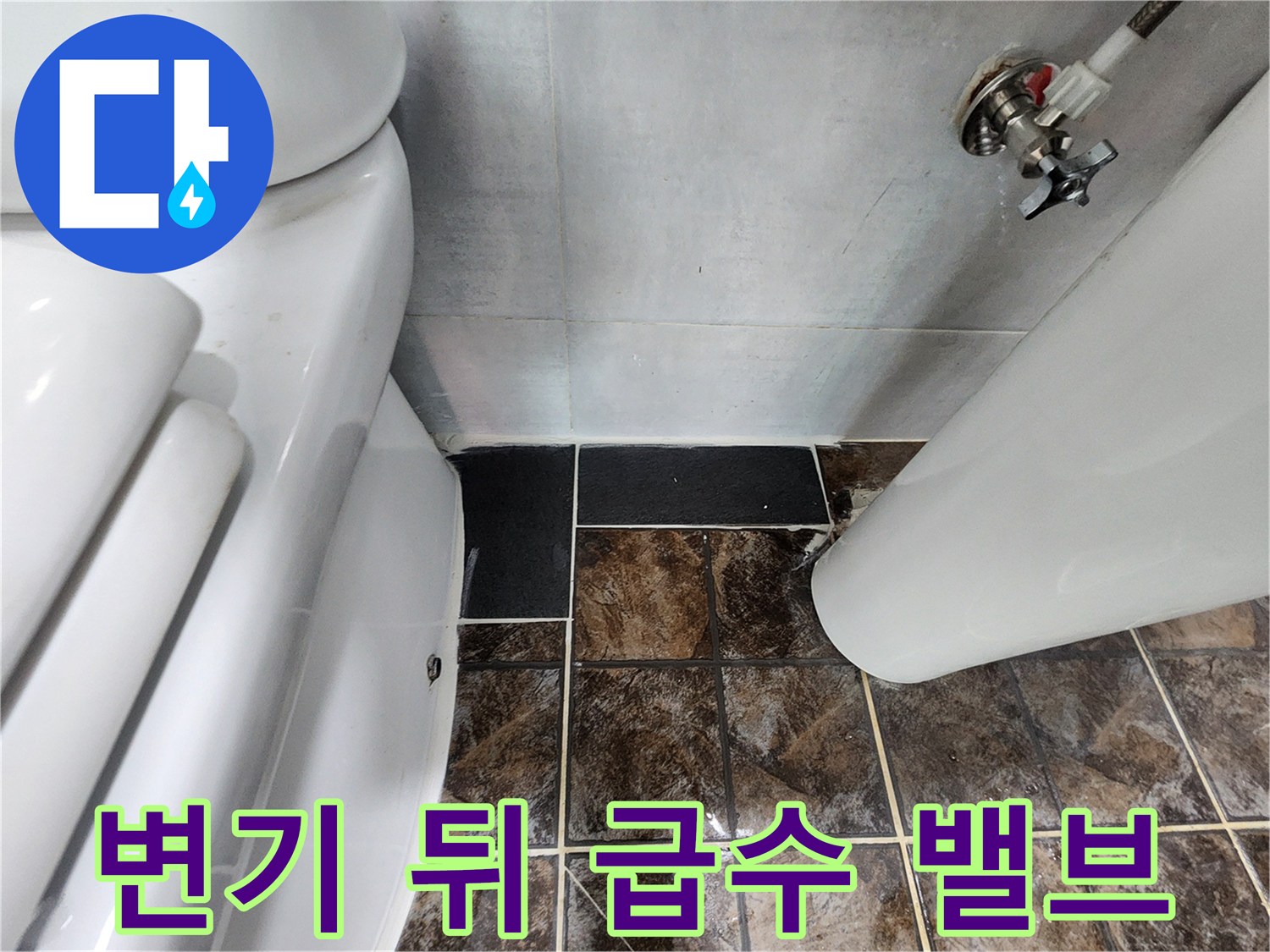 화장실 변기 옆 벽면에 설치된 급수용 밸브와 배관의 모습입니다.