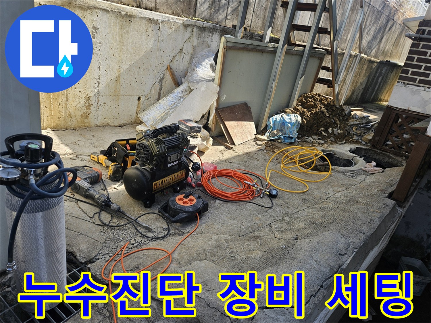 누수 공사 현장에서-정확한 진단을 위해-에어 콤프레셔-함마드릴-호스-전선릴 등-다양한 전문 장비들이-콘크리트 바닥 위에-준비되어 있는 모습