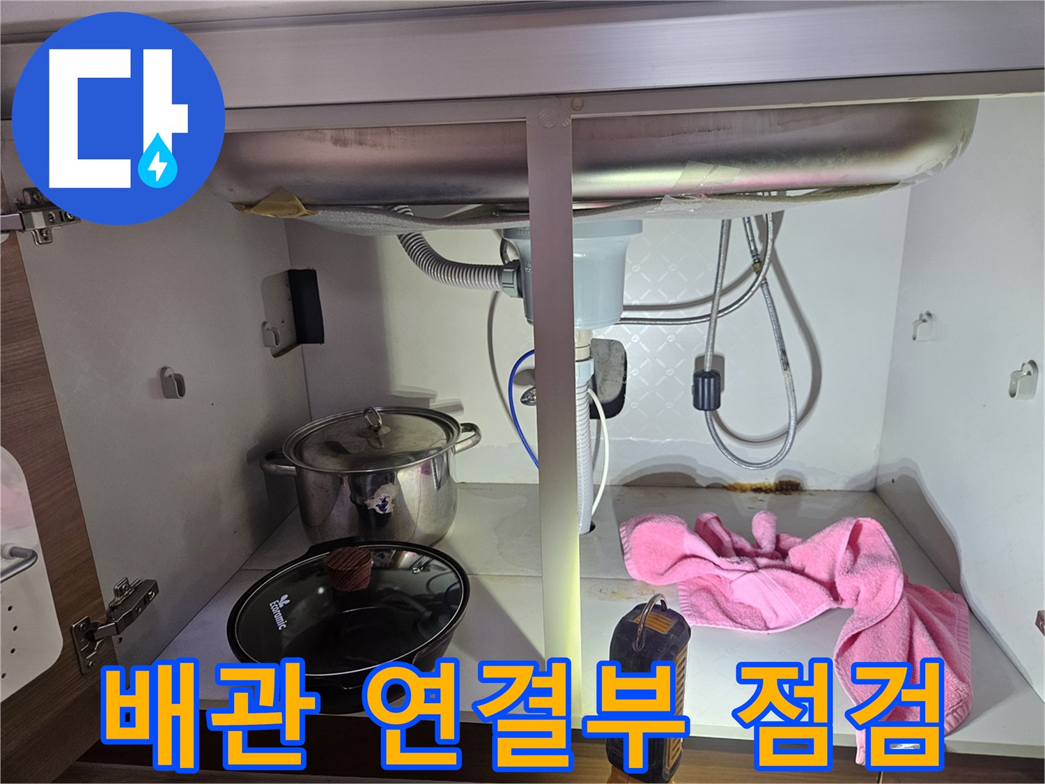 싱크대-하부의-배관-연결-부위에서-누수-여부를-정밀하게-점검하는-모습을-담은-사진입니다