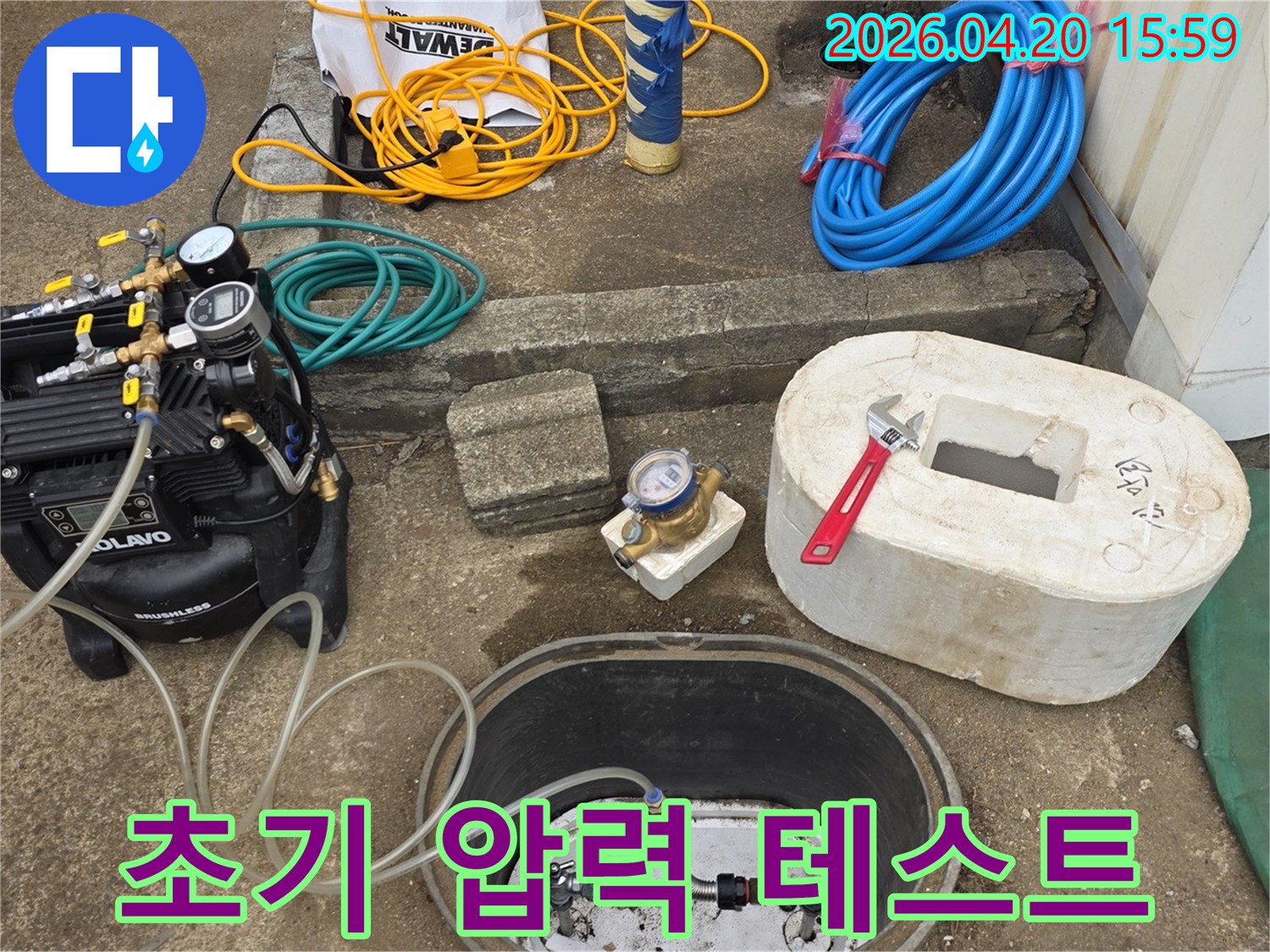 누수 탐지 작업을 시작하기 위해-초기 압력 테스트 장비를-수도 계량기함에 설치하는 모습