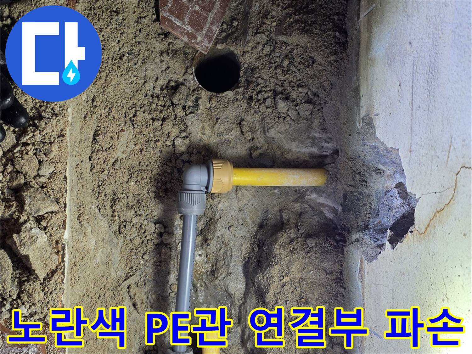 흙을 파내어 드러낸 노란색 수도 배관과 분기 부속의 모습