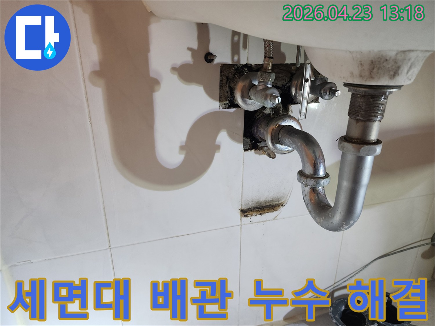 이 이미지는 양주 삼숭동 아파트 욕실 세면대 배수관에서 발생한-누수로 인해 벽면에 생긴 물자국과 곰팡이 흔적을 보여줍니다.