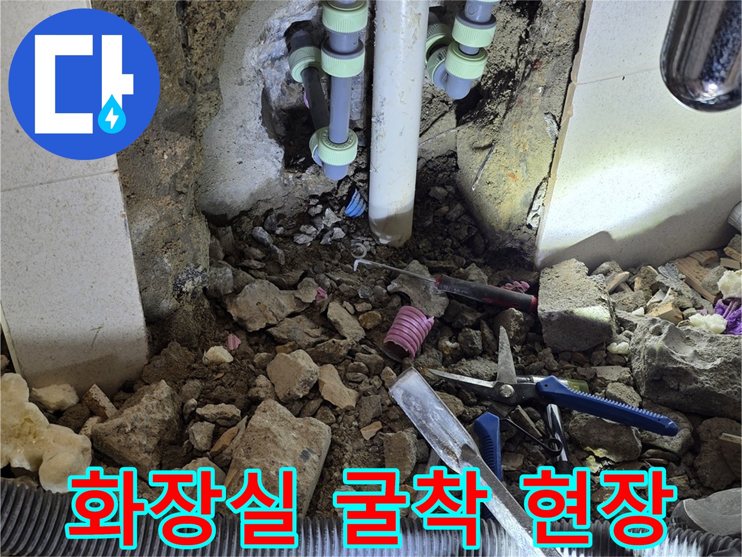 벽면 내부의 파손된 배관과 주변 작업 도구들