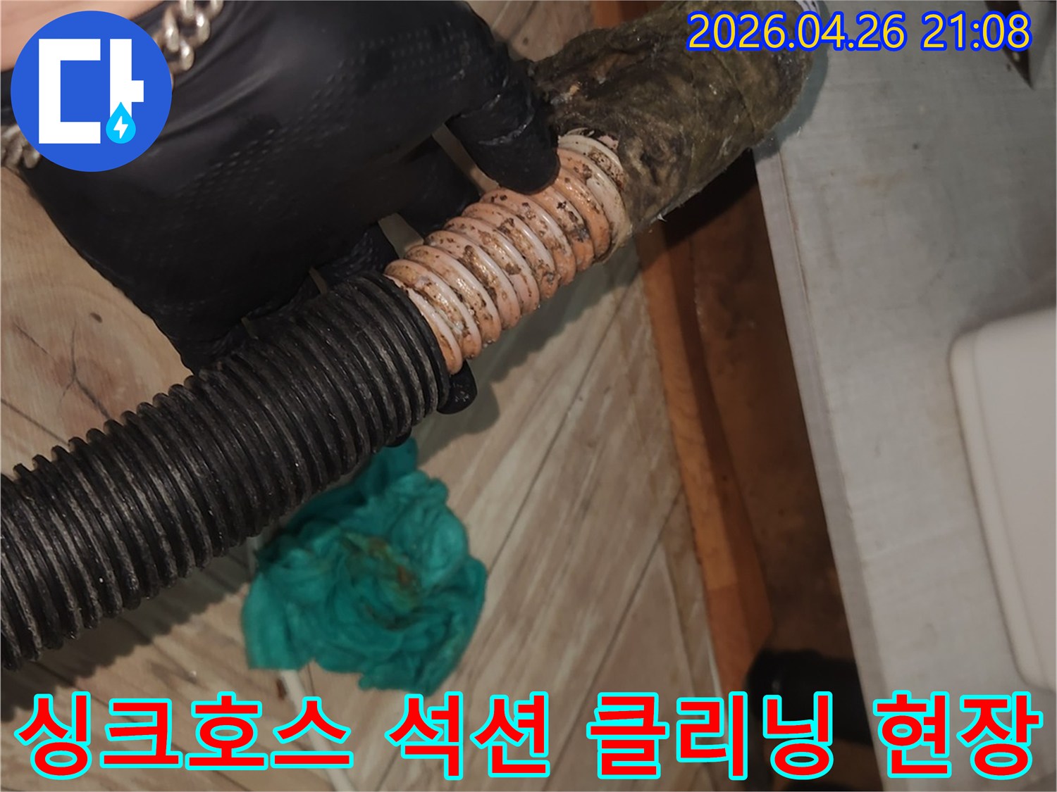 검은색 장갑을 낀 작업자가-오염된 싱크대 호스를-석션 클리닝으로 청소하는 모습
