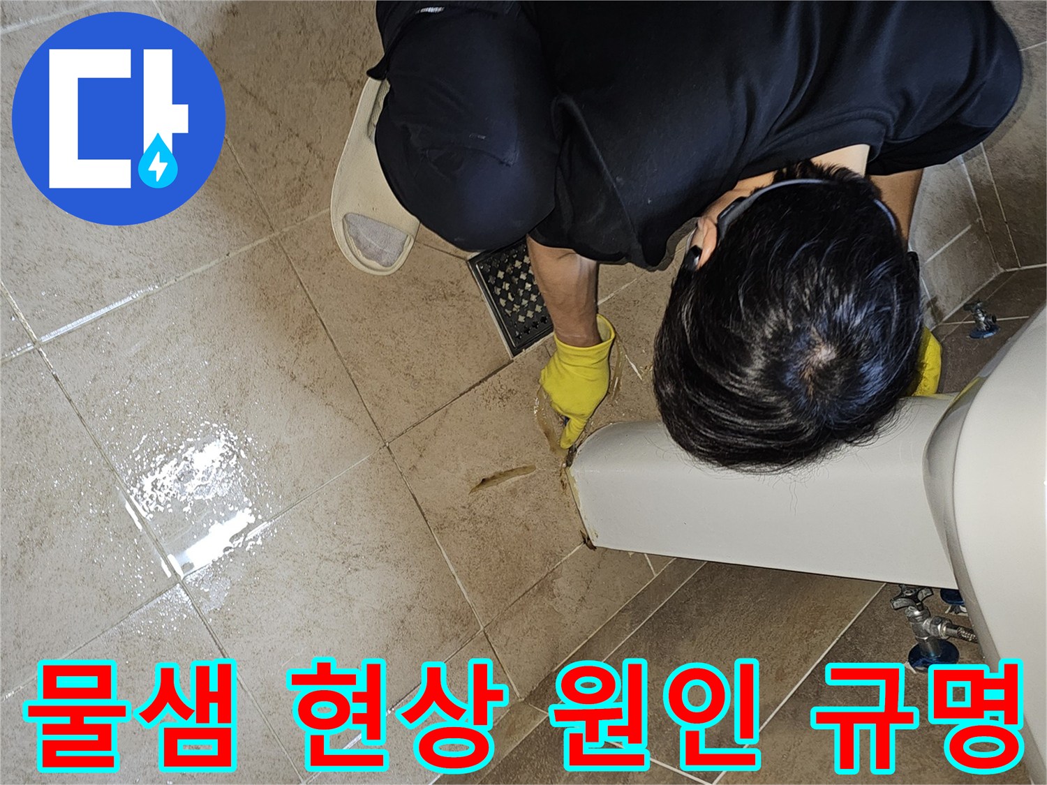전문 엔지니어가-노란 장갑을 끼고-욕실 바닥의 젖은 타일과-세면대 하단부를-집중적으로 관찰하며-누수 지점을 정확하게 규명하고 있습니다