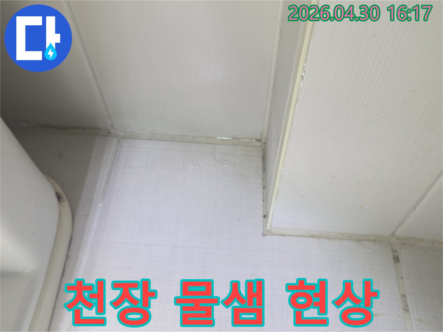 천장과 벽의 경계에서 물이 새어 나와-벽지가 젖어있는 상태를 보여주는-누수 발생 현장의 증거 사진