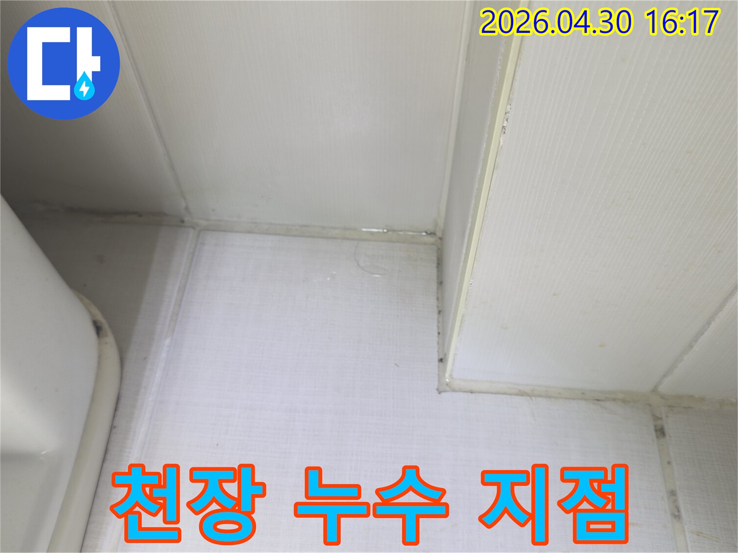 천장과 벽의 경계에서 물이 새어 나와-벽지가 젖어있는 상태를 보여주는-누수 발생 현장의 증거 사진