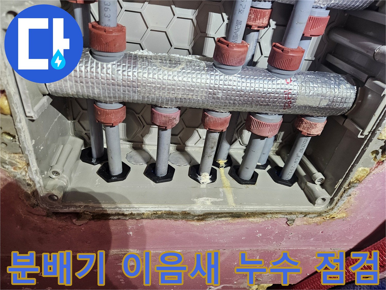 수도 분배기 배관 이음새 부위에서-누수 여부를 점검하는 모습