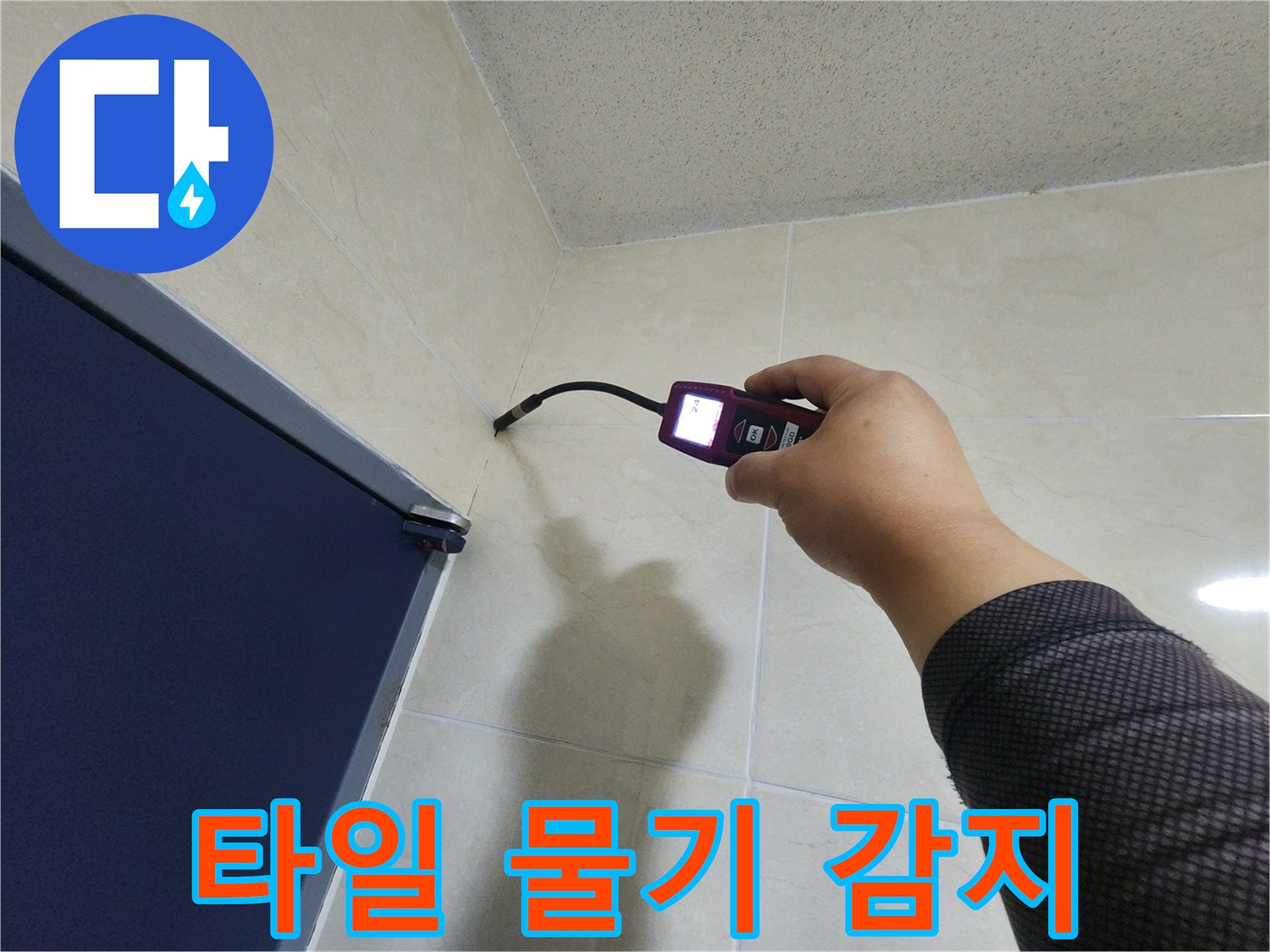 누수 전문 엔지니어가-타일 벽면의 미세한 틈새에서-고성능 탐지기로-숨겨진 물기를 정확히 감지하고 있습니다.
