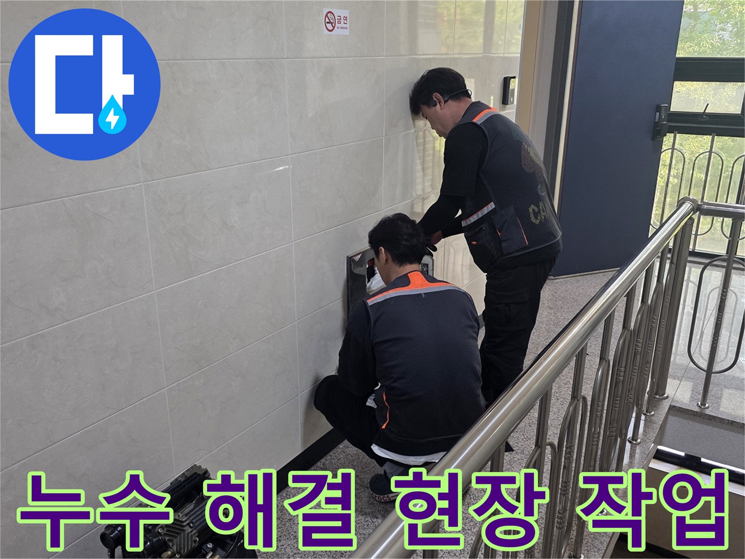 두 명의 전문 기술자가 건물 벽면의 누수 의심 지점을 정밀하게 탐지하며 신속하고 확실한 문제 해결을 위한 준비를 하고 있습니다.