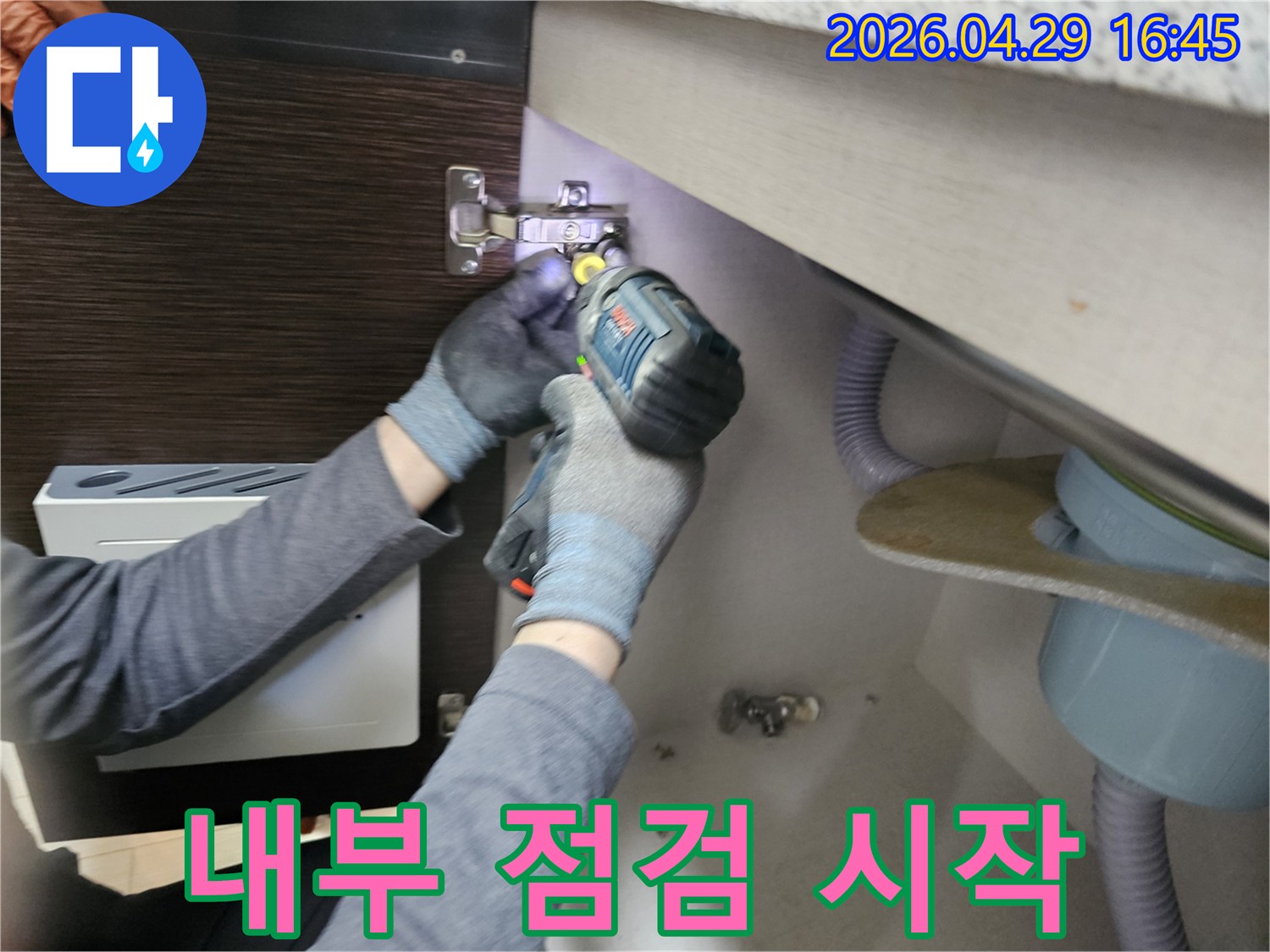 누수 엔지니어가-싱크대 누수-내부 점검을-시작하기 위해-하부장 패널을-분리하는-장면