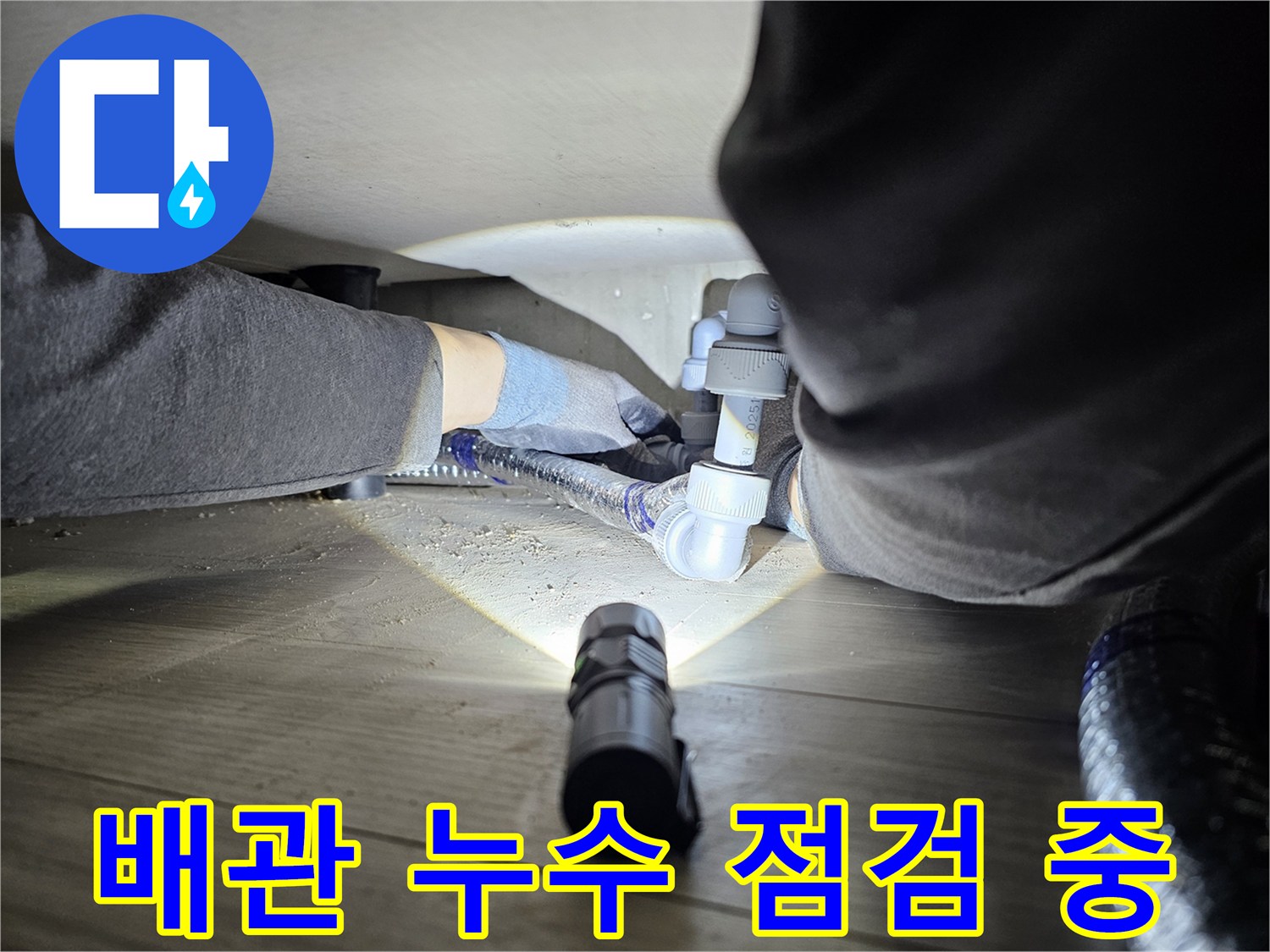 누수-탐지-전문가가-어두운-공간에서-배관-연결부를-정밀하게-점검하는-모습