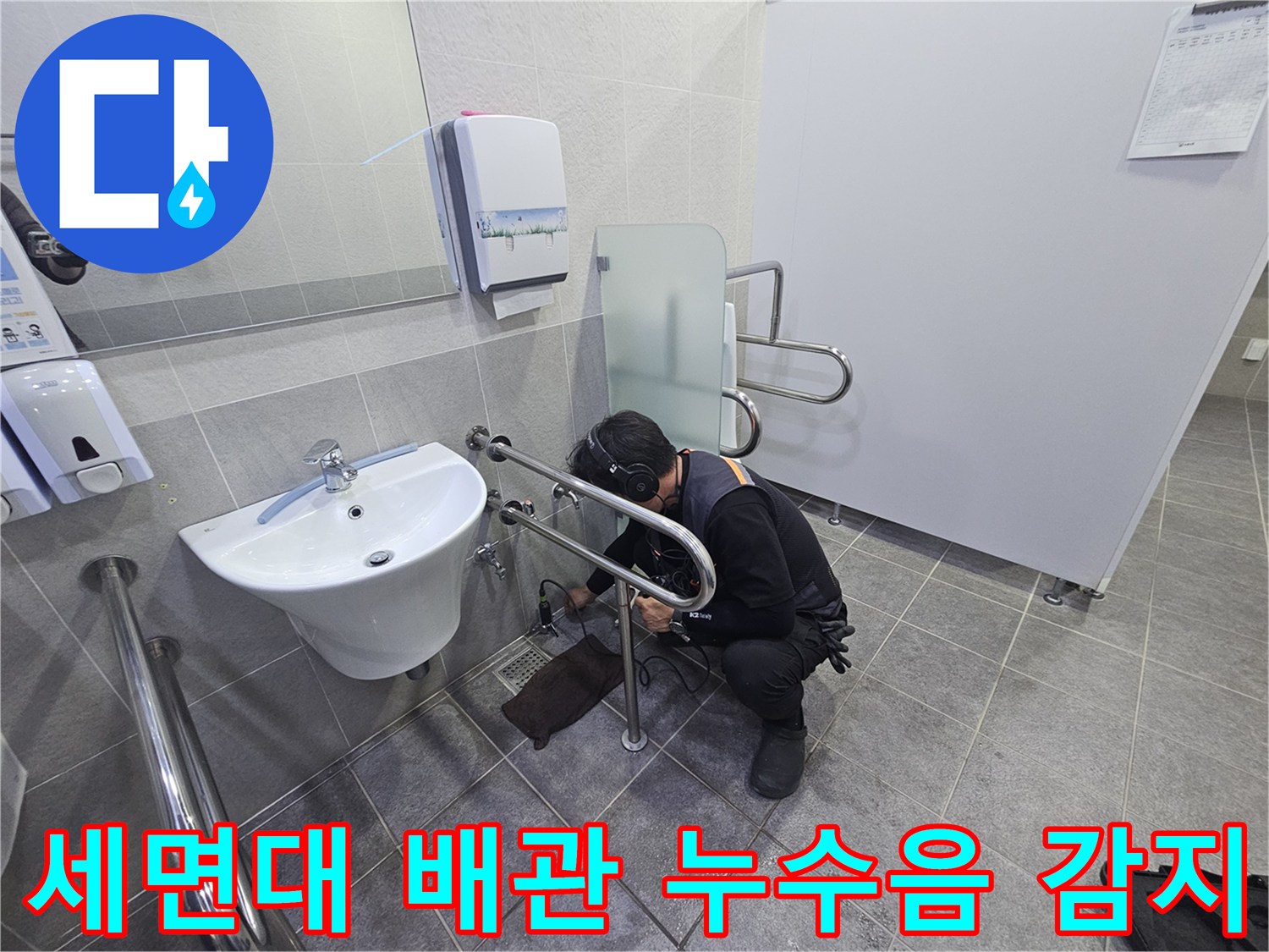 누수 전문가가-청음식 탐지기로-화장실 세면대 하부 배관에서-누수음을 정밀하게 감지하는 모습