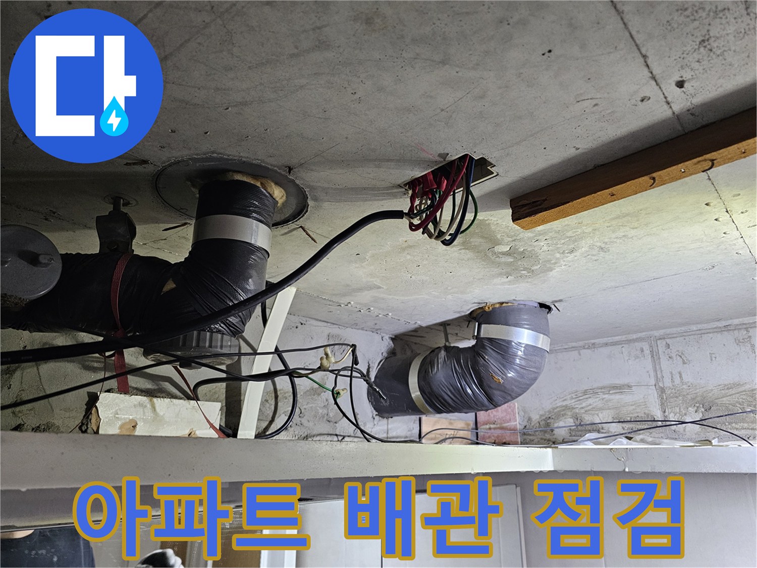 콘크리트 천장 아래-설치된-배관과-전기 배선이-엉켜있는-누수 현장-사진입니다.