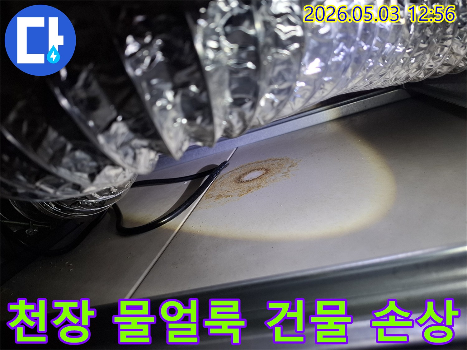 천장 마감재에 발생한 물얼룩을-조명으로 비춰 건물 손상 여부를 진단하는 모습입니다.