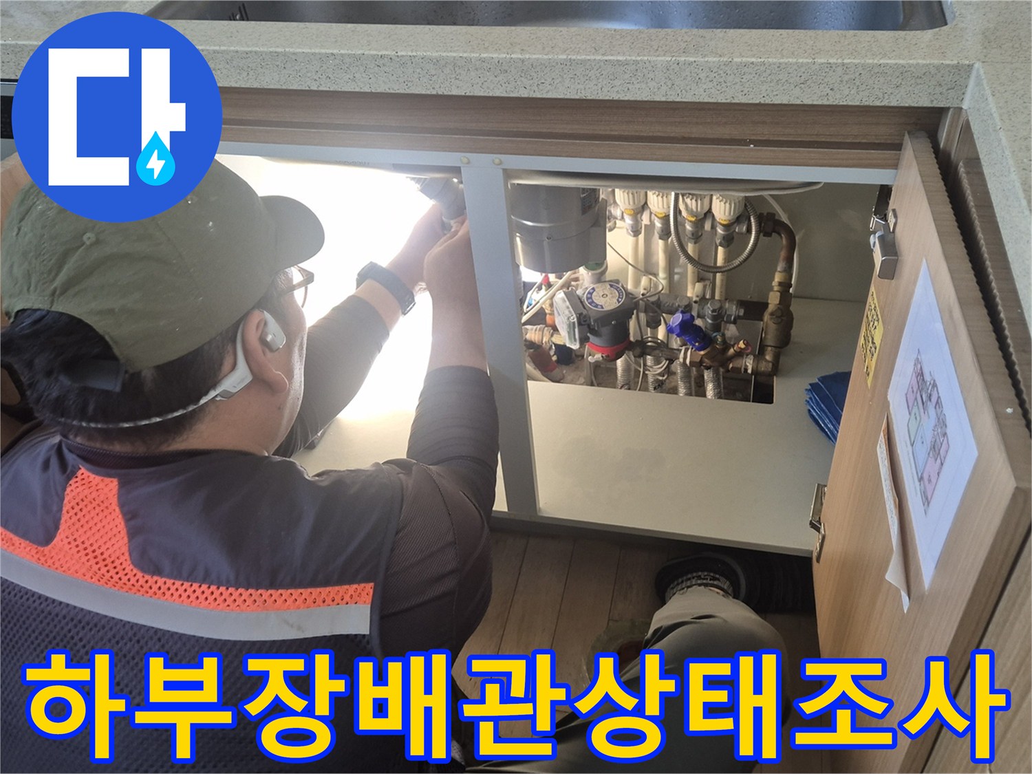 용인 수지구-싱기대 하부장 안쪽의 온수 관로를 점검하는 작업 장면